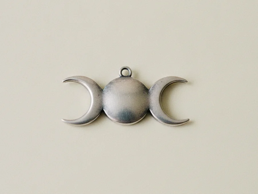 Detalle del colgante de la triple luna sobre lino